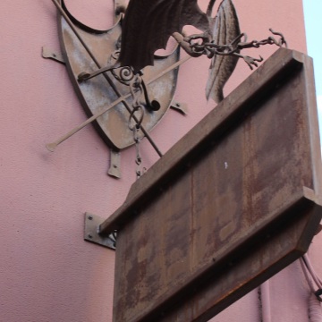 Escudo con un dragón forjado sujetando un cartel