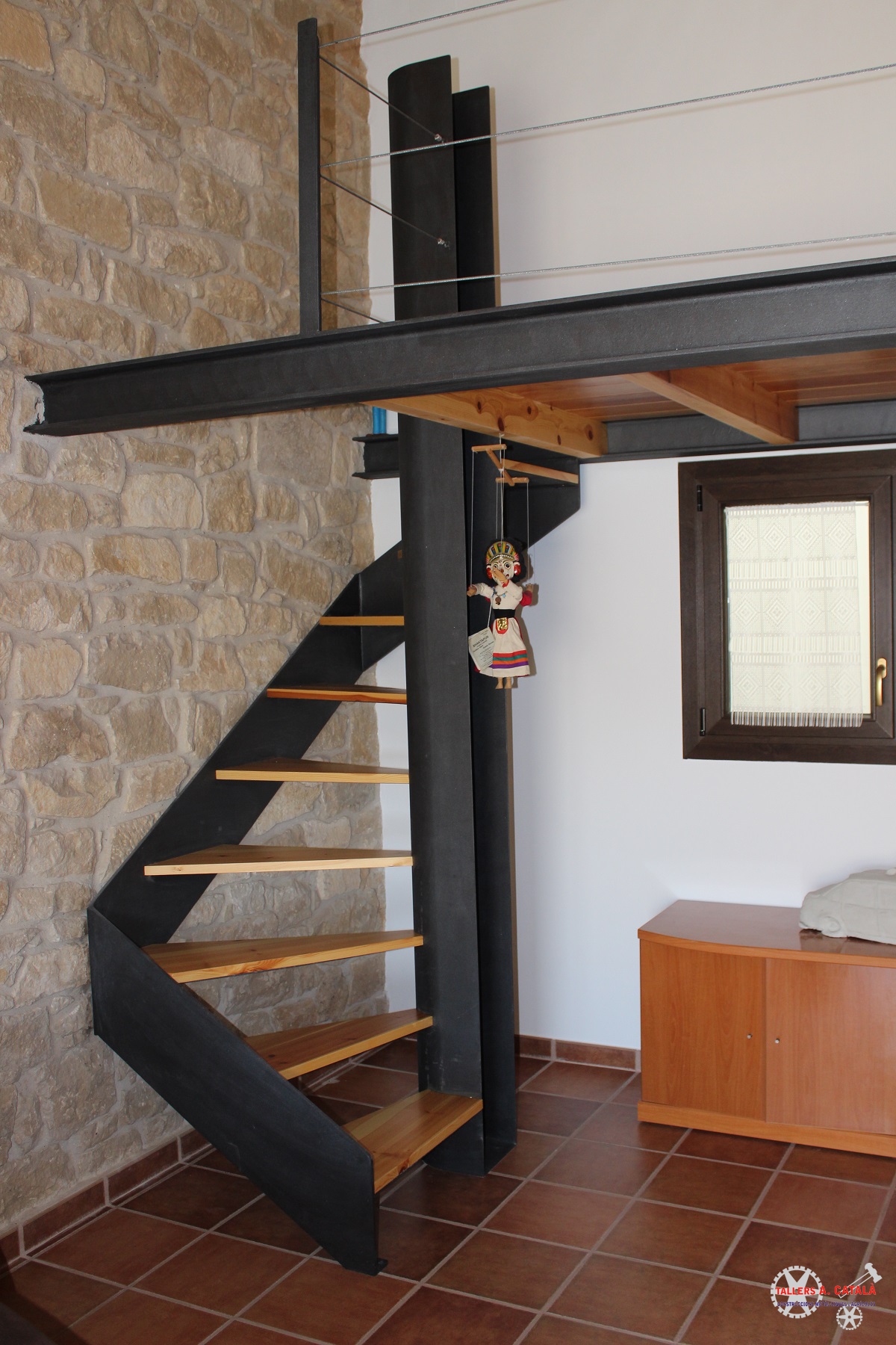 Escalera de caracol con de madera y altillo de diseño con acero pintado de forja y barandilla de sirga horizontal A. Català