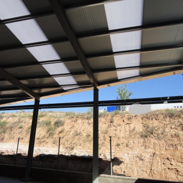 Estructura metálica con paredes y cubiertas de panel aislante; y claraboyas en el techo y las paredes para aportar luz natural al interior de la estructura.