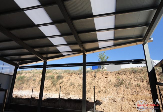 Estructura metàl·lica, amb parets i cobertes de panell aïllant i claraboies en sostre i parets per donar llum natural a l'interior de l'estructura.