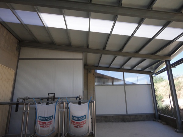 Estructura metàl·lica, amb parets i cobertes de panell aïllant i claraboies en sostre i parets per donar llum natural a l'interior de l'estructura.